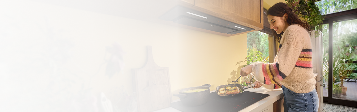 Kobieta stoi przy okapie w żółtej kuchni