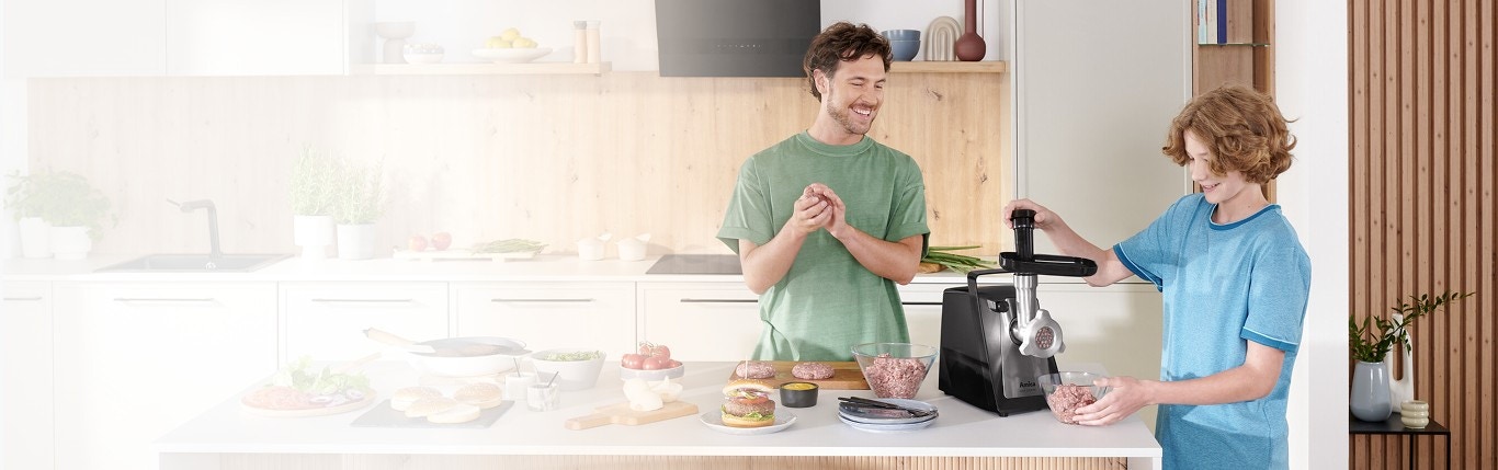 Tata z synem z mielą mięso z maszynce do mielenia