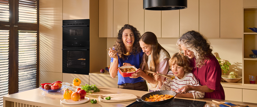 mama z córką, synem i babcią gotują w kuchni