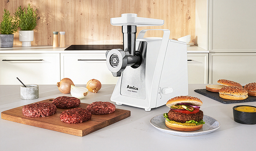 maszynka do mielenia i zmielone kotlety na desce