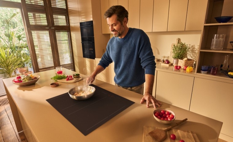 Mężczyzna gotuje na matowej płycie indukcyjnej