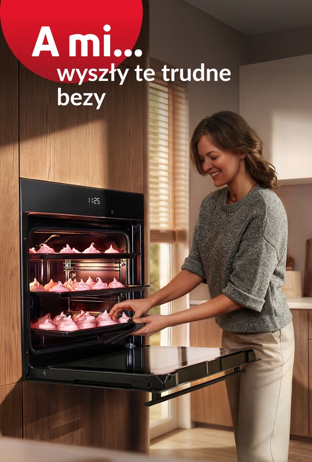 Kobieta wyjmuje różowe bezy z piekarnika