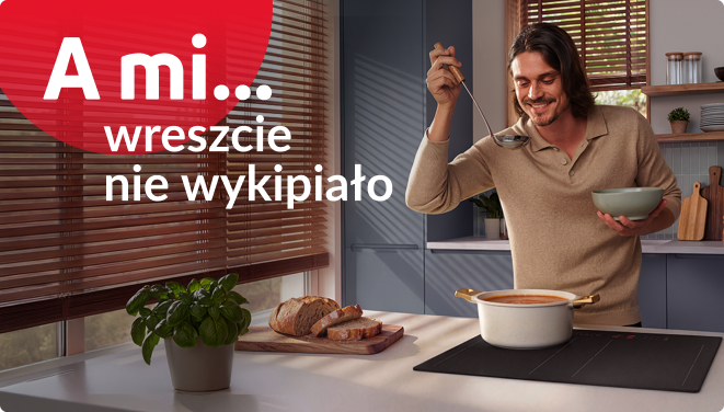 A mi wreszcie nie wykipiało. Mężczyzna gotuje zupę pomidorową na płycie indukcyjnej.