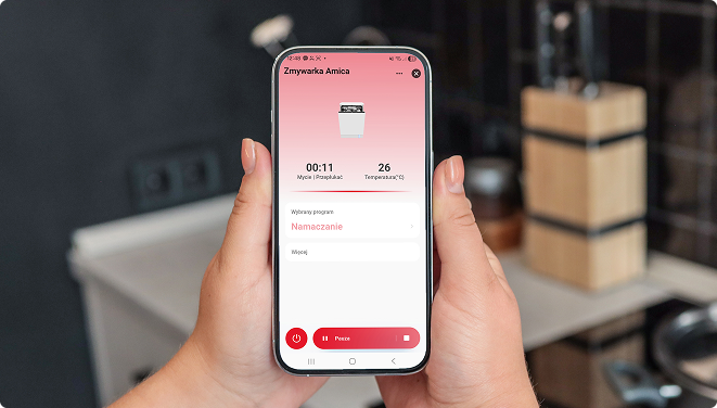 telefon trzymany w dłoniach, na ekranie wyświetla się aplikacja