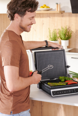 mężczyzna przygotowuje jedzenie na grillu elektrycznym