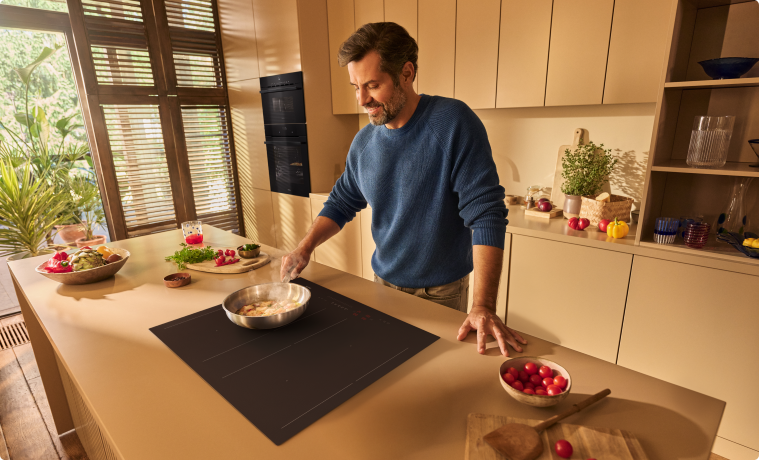 Mężczyzna gotuje obiad na płycie indukcyjnej