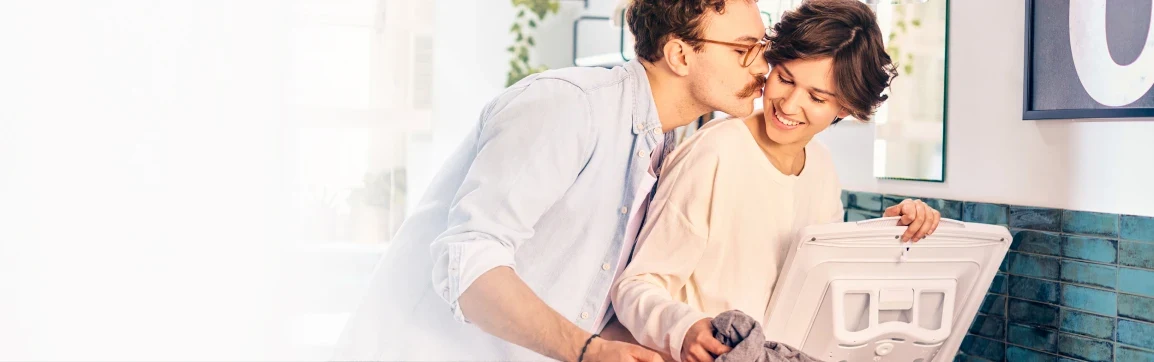 Kobieta i mężczyzna przy pralce ładowanej od góry