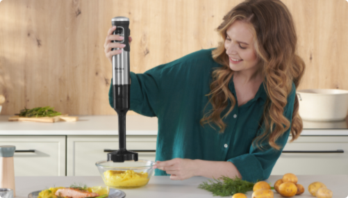 Kobieta blenduje ż&oacute;łte warzywa