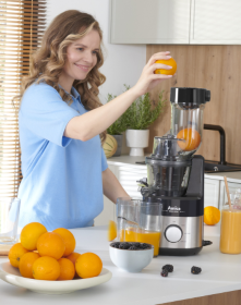 kobieta wyciska sok z pomarańczy