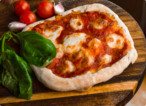 Pizza, obok bazylia, czosnej i pomidory