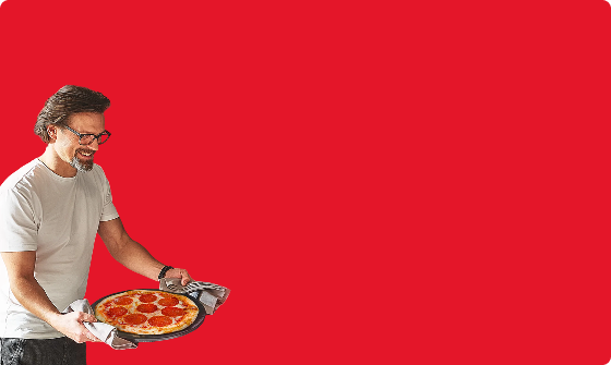 mężczyzna z pizzą w rękach na czerwonym tle