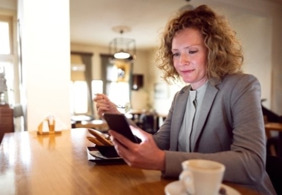 kobieta w kawiarni, z telefonem w ręce