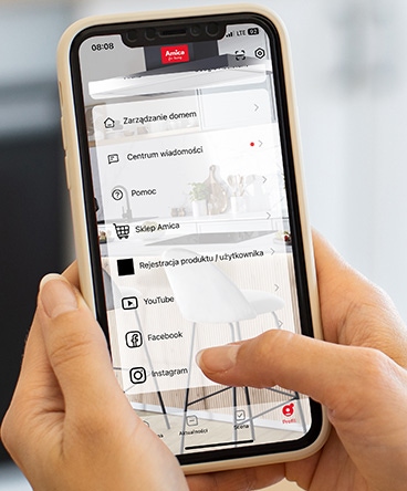 kobieta trzyma w dłoni telefon, na ekranie widać aplikacje z zaznaczoną opcją Pomoc