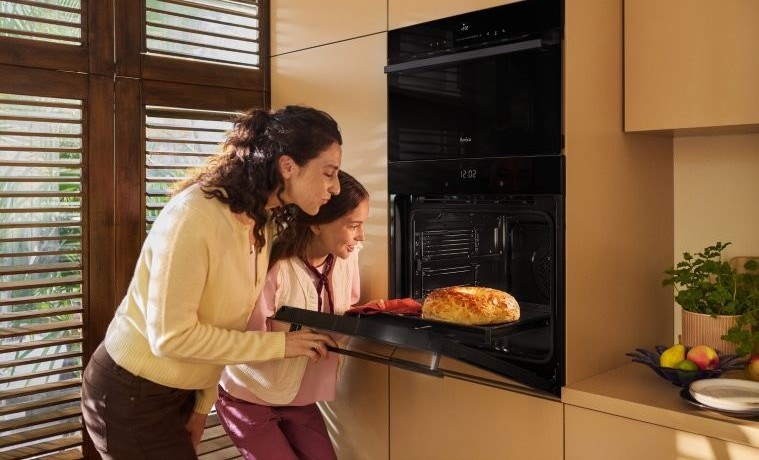 Mama z córką wyjmują chleb z piekarnika