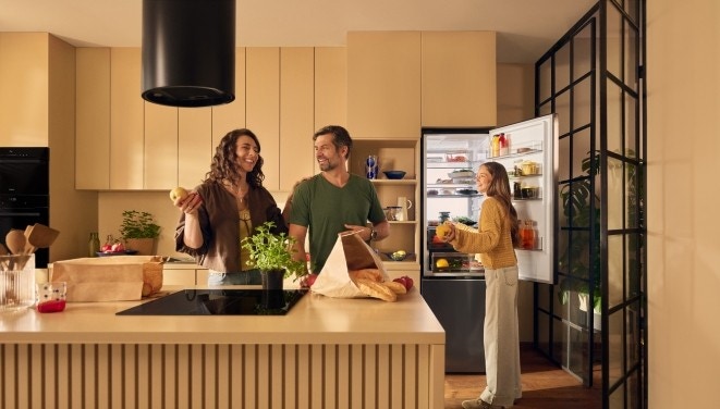 rodzina w kuchni, widać płytę indukcyjną, okap i lod&oacute;wkę